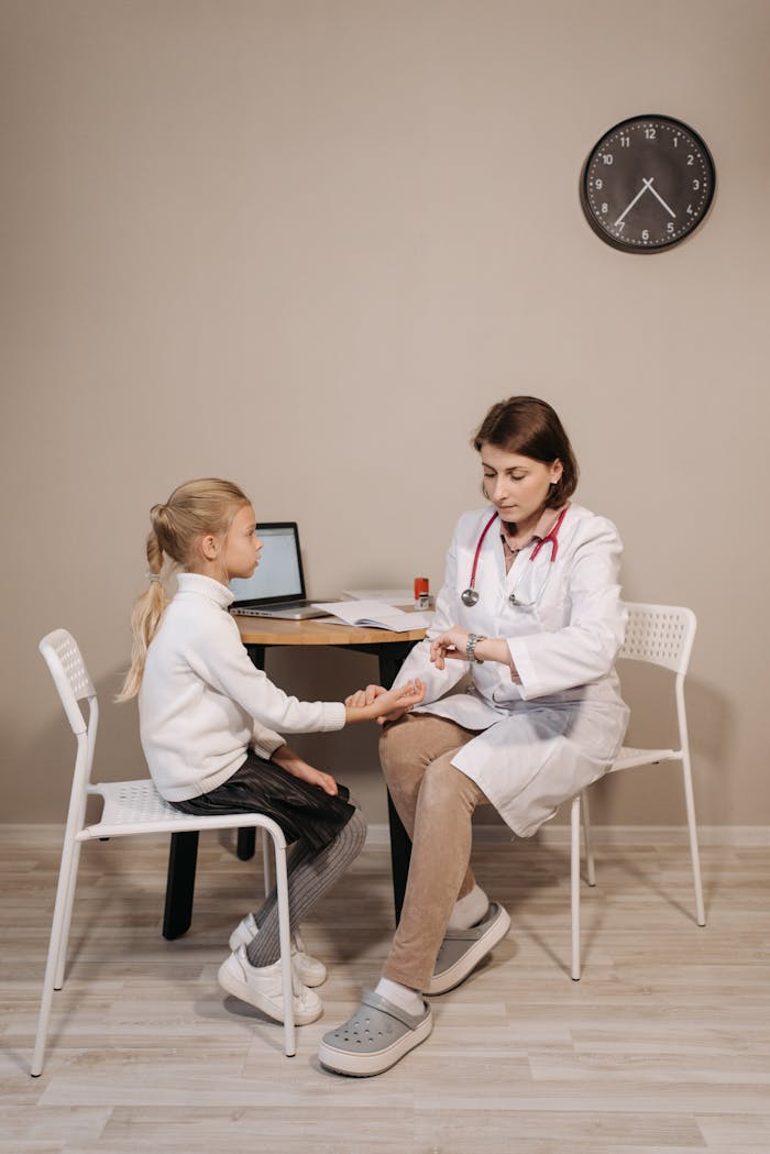 A pediatrician consults a young girl in a clinic setting, emphasizing healthcare and wellness.